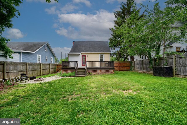 rear view of property featuring an outdoor fire pit and a wooden deck