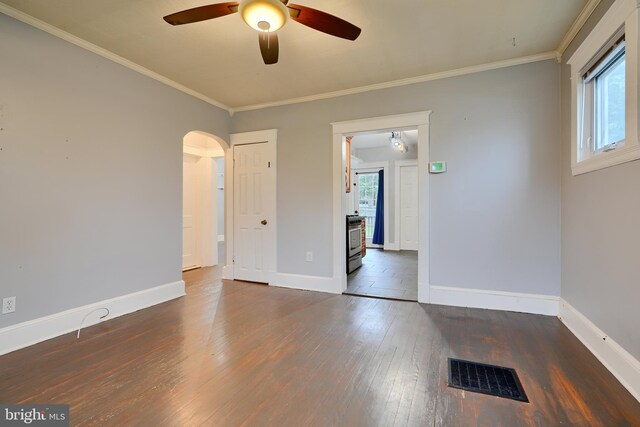 unfurnished room with ceiling fan, hardwood / wood-style flooring, baseboards, crown molding, and arched walkways