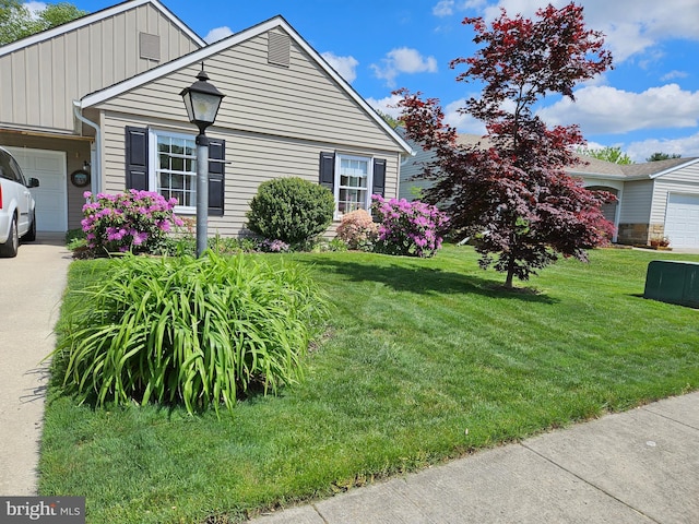 view of side of home with board and batten siding, a lawn, and an attached garage