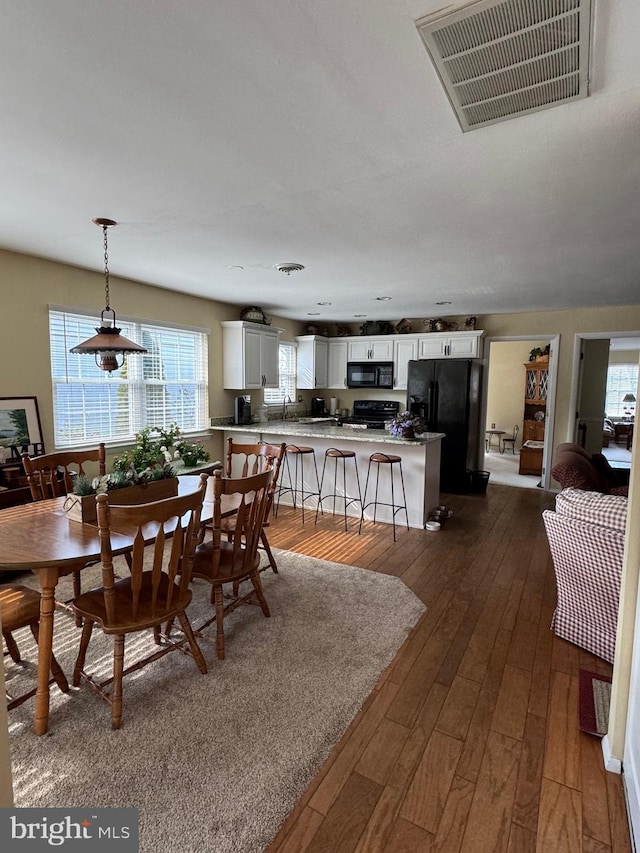 dining space with dark wood-style floors and visible vents