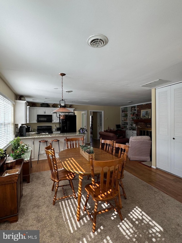 dining area featuring wood finished floors and visible vents