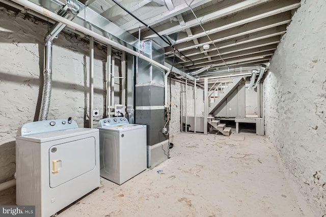 unfinished basement with separate washer and dryer and heating unit