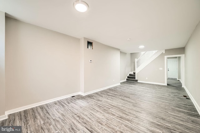 finished below grade area with stairs, wood finished floors, and baseboards