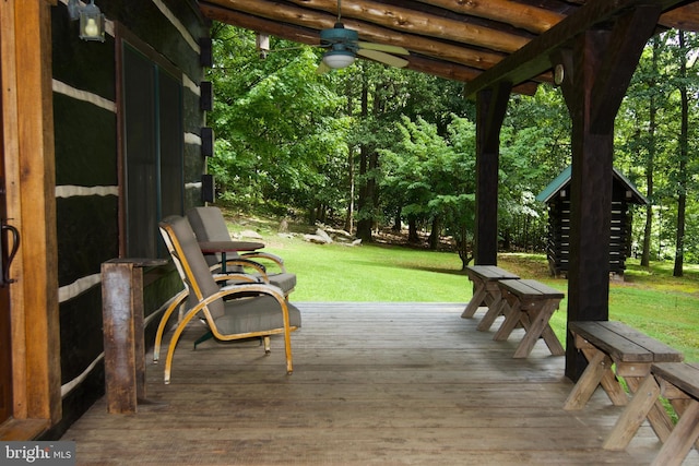 wooden deck featuring ceiling fan and a yard