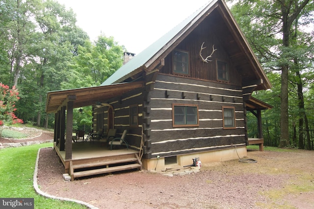 exterior space featuring log exterior and a chimney