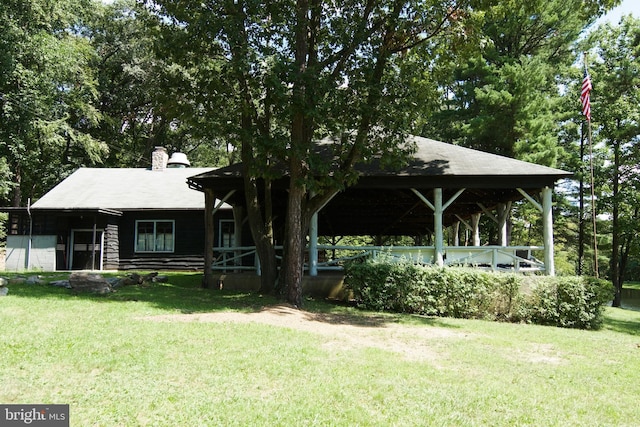 view of front facade with a chimney and a front yard