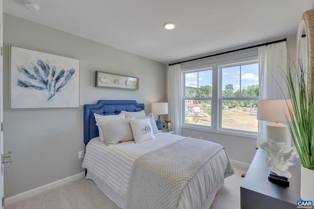 bedroom featuring baseboards and light colored carpet