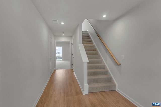 stairs with recessed lighting, wood finished floors, visible vents, and baseboards