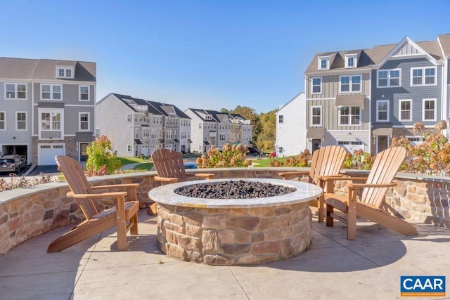 view of patio / terrace featuring an outdoor fire pit and a residential view