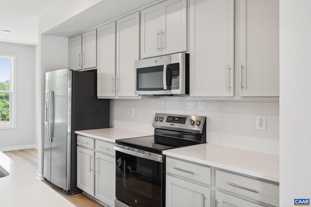 kitchen featuring light countertops, appliances with stainless steel finishes, and decorative backsplash