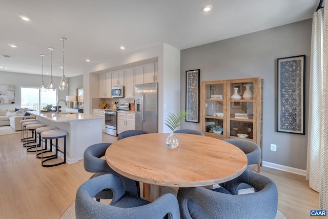 dining space featuring recessed lighting, light wood-style flooring, and baseboards