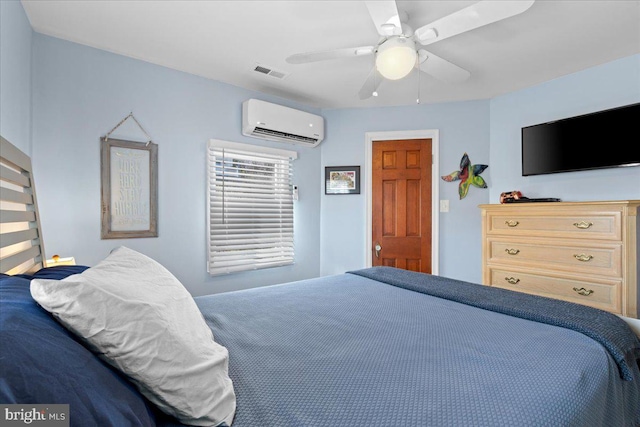 bedroom with a ceiling fan, a wall unit AC, and visible vents