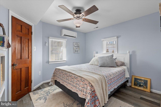 bedroom featuring multiple windows, a wall unit AC, wood finished floors, and visible vents