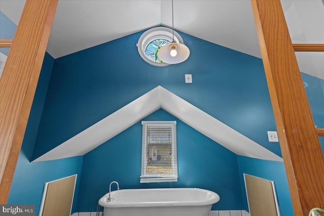 interior space with a soaking tub and vaulted ceiling