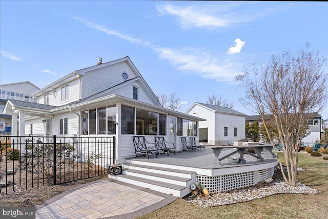 back of house featuring a sunroom, fence, and a wooden deck