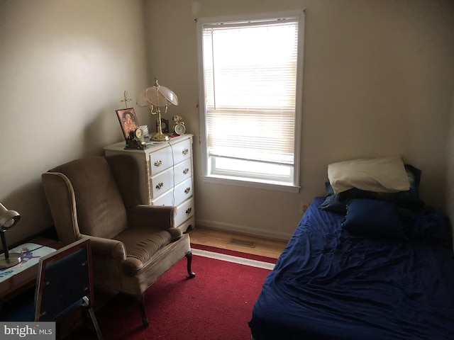 bedroom with light wood-style floors, visible vents, and baseboards