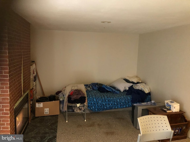 bedroom with carpet floors and a brick fireplace