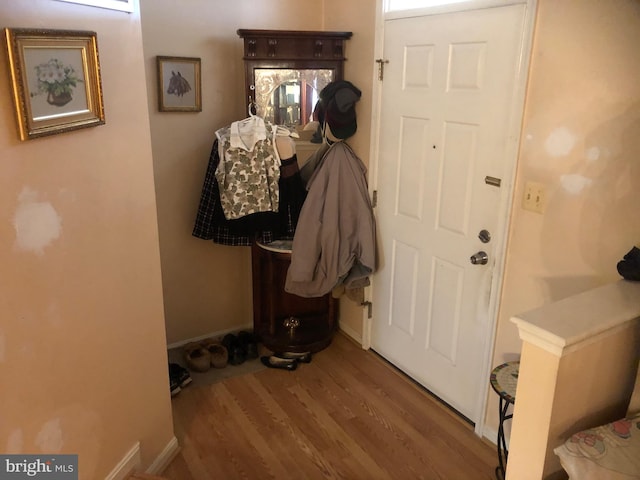 doorway featuring baseboards and wood finished floors