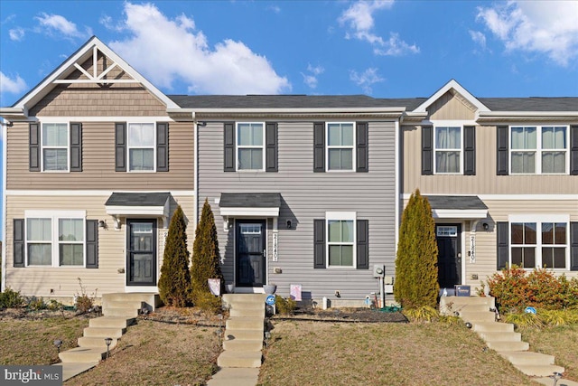 townhome / multi-family property featuring a front lawn