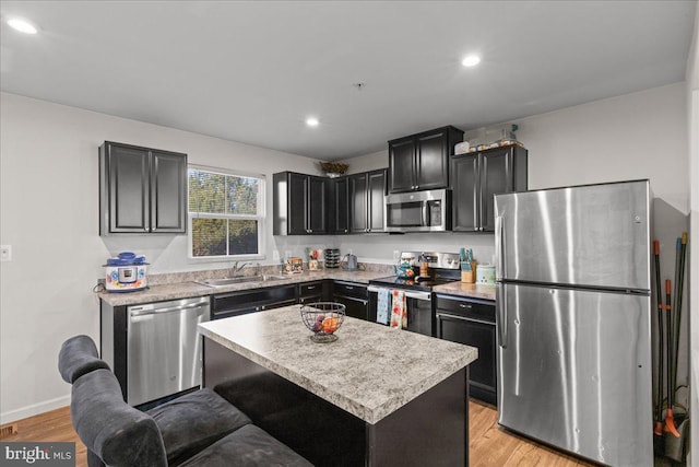 kitchen with light wood-style flooring, appliances with stainless steel finishes, light countertops, and a sink