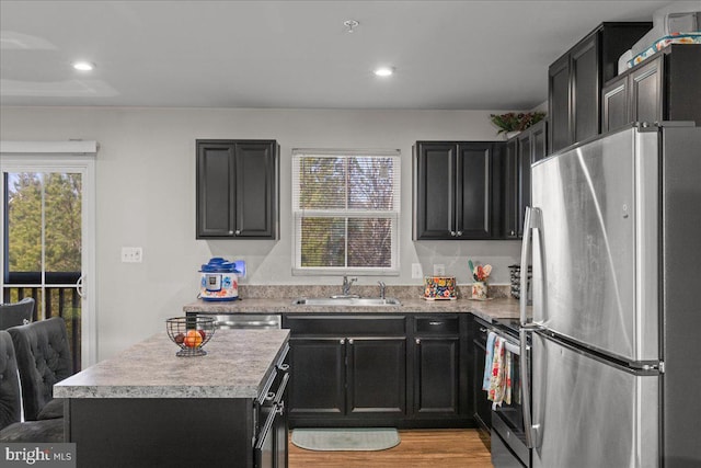 kitchen with a sink, stainless steel appliances, a wealth of natural light, and light countertops