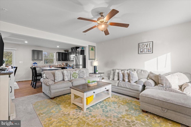 living area with recessed lighting, baseboards, light wood-type flooring, and ceiling fan