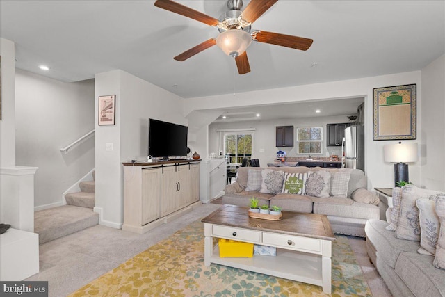 living room with stairway, recessed lighting, baseboards, and light carpet