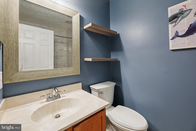 bathroom featuring toilet and vanity