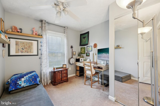 office space featuring carpet flooring, a ceiling fan, and baseboards