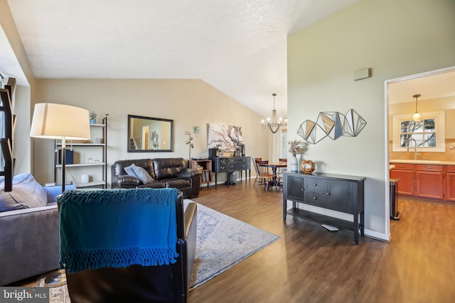 living room featuring an inviting chandelier, vaulted ceiling, baseboards, and dark wood-type flooring