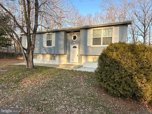 split foyer home featuring a patio and fence