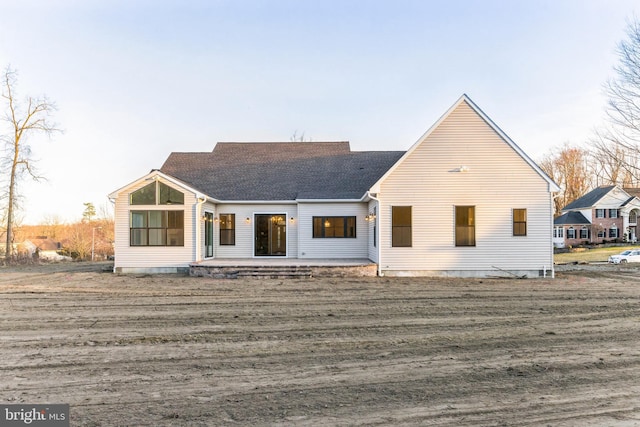 back of property with a patio and a shingled roof