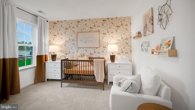 bedroom featuring light colored carpet, visible vents, and wallpapered walls