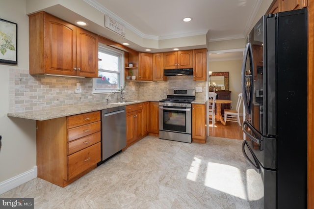 kitchen featuring under cabinet range hood, appliances with stainless steel finishes, and brown cabinets