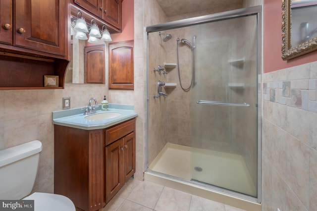 full bathroom featuring toilet, tile patterned floors, vanity, a shower stall, and tile walls