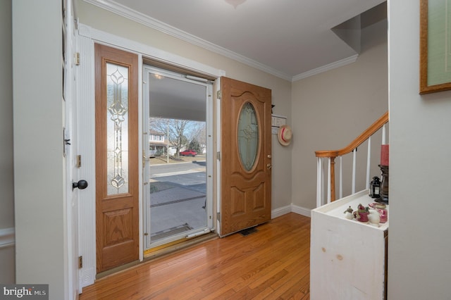 foyer with stairs, light wood-style floors, baseboards, and crown molding