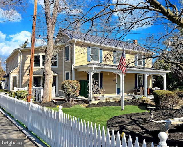 view of front facade with covered porch and a fenced front yard