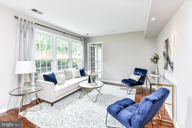 living room with baseboards, visible vents, wood finished floors, and recessed lighting