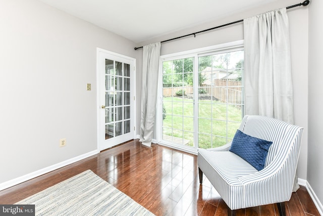 living area with baseboards and wood finished floors