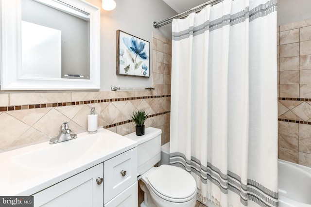 bathroom with tile walls, vanity, toilet, and shower / tub combo with curtain