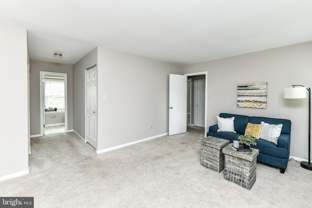 sitting room featuring light carpet and baseboards