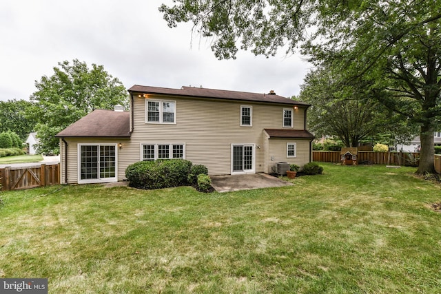 back of property with cooling unit, a yard, a chimney, and a patio