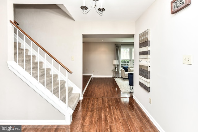 foyer with baseboards, stairway, and wood finished floors