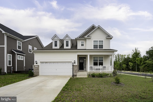 view of front of house with covered porch, a front yard, concrete driveway, and a garage