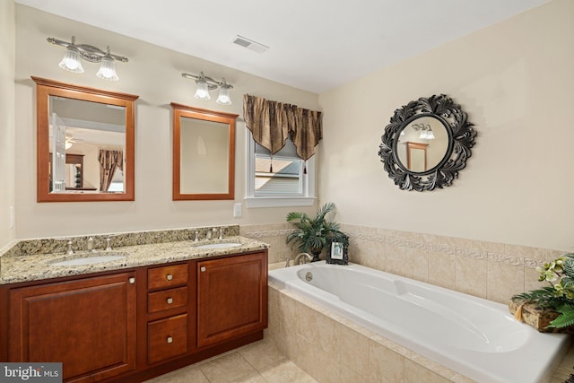 bathroom with visible vents, a sink, a garden tub, and double vanity