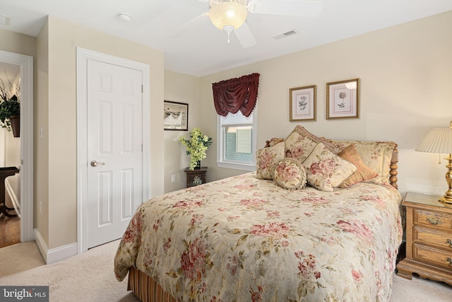 carpeted bedroom featuring baseboards, visible vents, and a ceiling fan