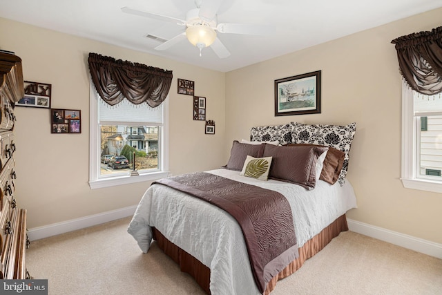 carpeted bedroom with a ceiling fan, visible vents, and baseboards