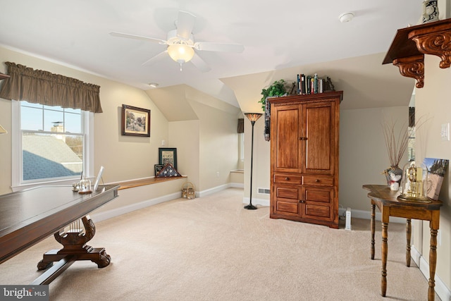 exercise room featuring lofted ceiling, light carpet, ceiling fan, and baseboards