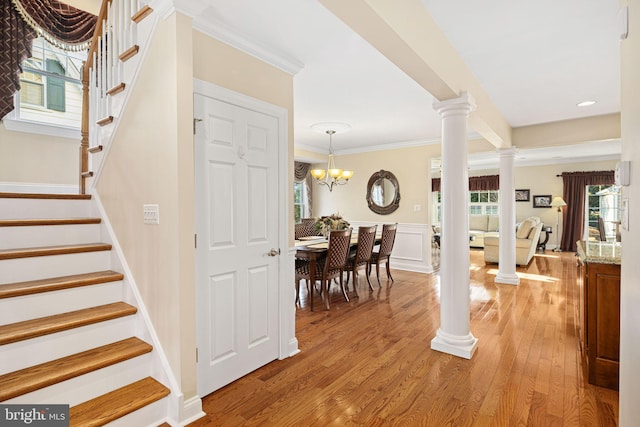 entryway with stairs, decorative columns, and light wood-style floors