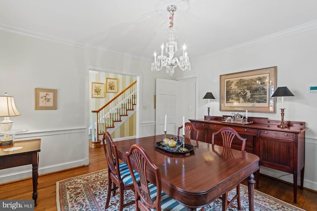 dining room featuring stairs, baseboards, wood finished floors, and crown molding